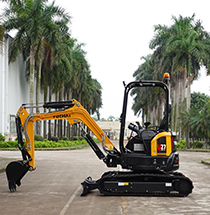 Yellow Yuchai Americas excavator on a paved road lined with palm trees, showcasing compact construction equipment in a tropical setting.